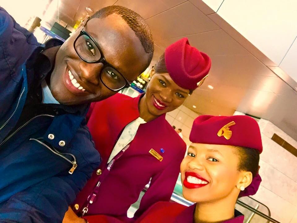 Three people posing with an airline crew member in uniform